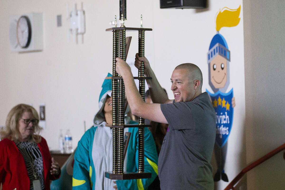 Principal Ronald Kamman raises a trophy during a ceremony celebrating their school as the top f ...