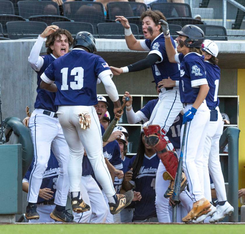 Shadow Ridge batter Thomas Moore JR. (13) is cheered after scoring by teammates versus Legacy d ...