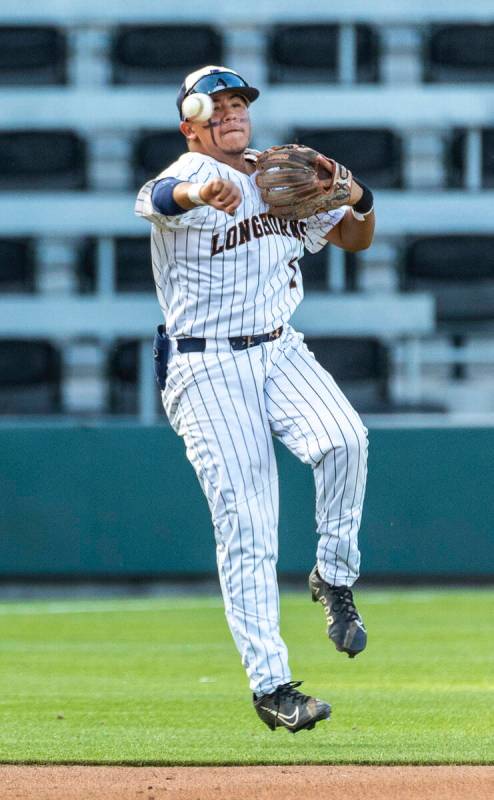 Legacy short stop Richard Leon (1) throws to first base as a Shadow Ridge runner sprints there ...