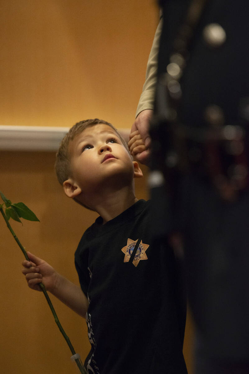 Liam Walker, 4, looks up at his father Lt. Dave Walker of the Metropolitan Police Department as ...