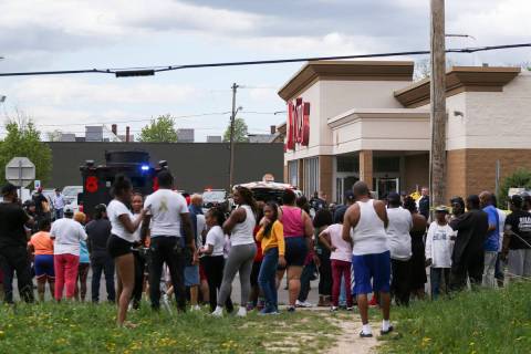 A crowd gathers as police investigate after a shooting at a supermarket on Saturday, May 14, 20 ...