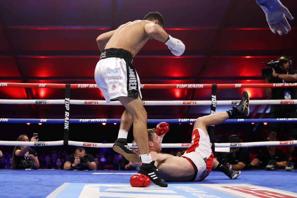 Janibek Alimkhanuly, left, leaps over Danny Dignum after knocking him down in the first round o ...