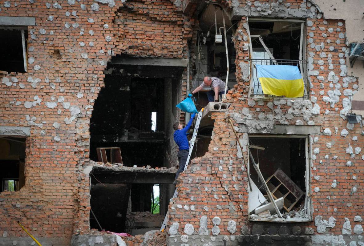 Residents take out their belongings from their house ruined by the Russian shelling in Irpin cl ...
