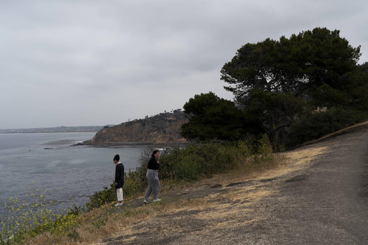 Two women stand near an ocean cliff in Palos Verdes Estates, Calif., Monday, May 23, 2022. Four ...