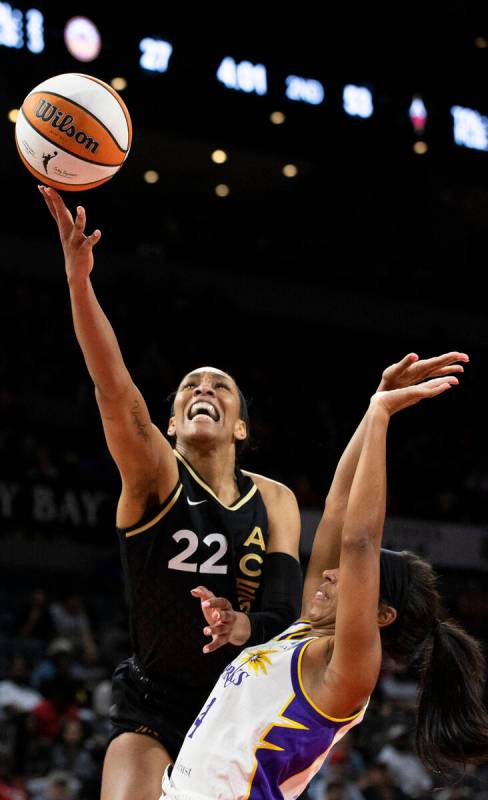 Aces forward A'ja Wilson (22) drives past Los Angeles Sparks guard Lexie Brown (4) in the first ...