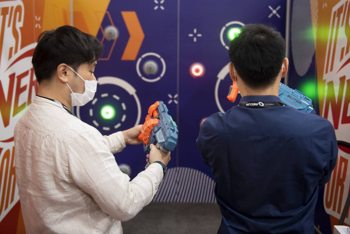 Kelvin Lam, left, and George Tree, of Thailand, play a Nerf game at the Hasbro booth during the ...