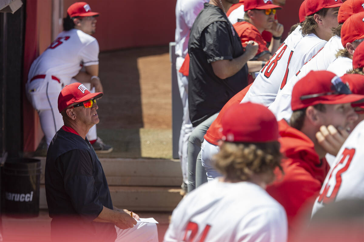 UNLV head coach Stan Stolte, left, watches the game against UNR from the dugout during an NCAA ...