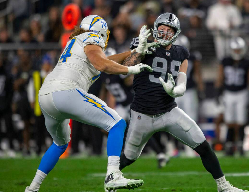 Raiders defensive end Maxx Crosby (98) works to get past Los Angeles Chargers offensive tackle ...