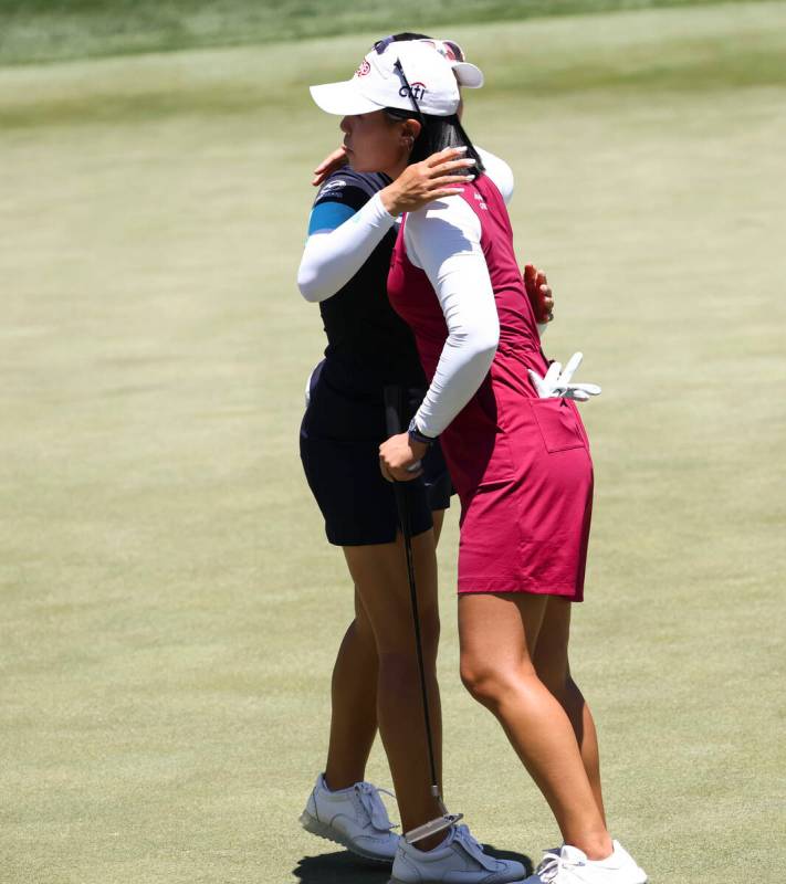 Kelly Tan, left, embraces Danielle Kang after Kang lost to Tan at the 12th hole during the firs ...
