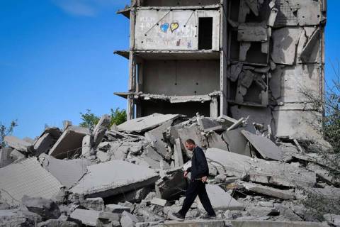 A local resident walks next to a house destroyed in a Russian shelling in Kramatorsk, Ukraine, ...