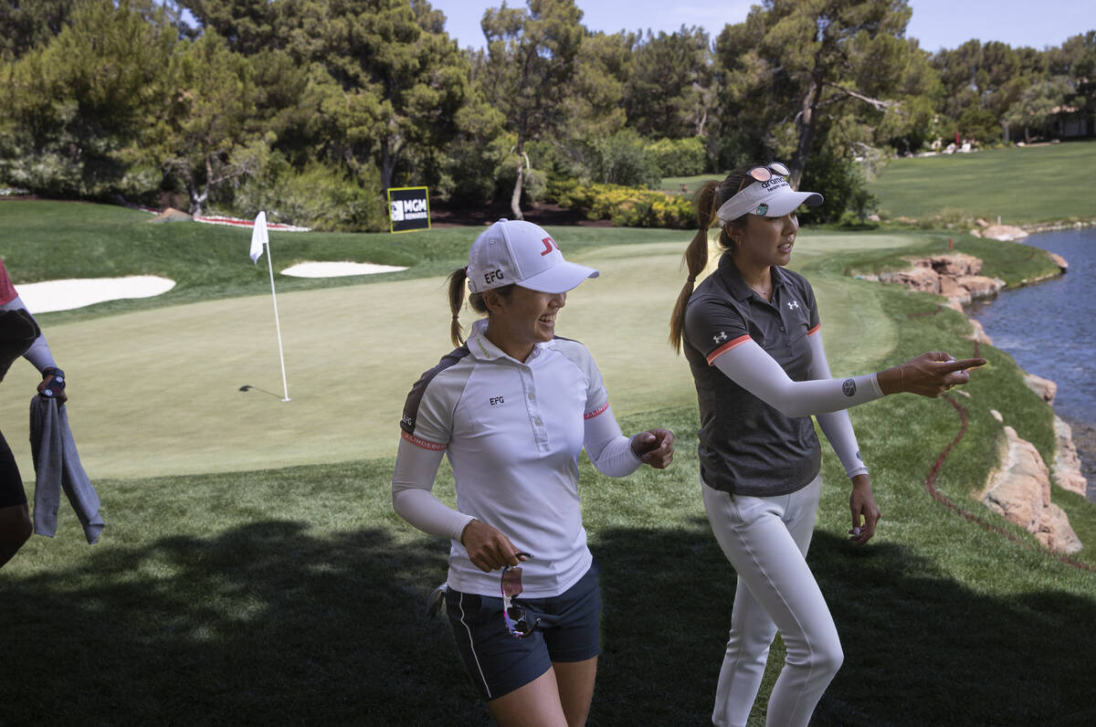 Tiffany Chan, left, and Alison Lee talk while walking from the ninth hole during the second day ...
