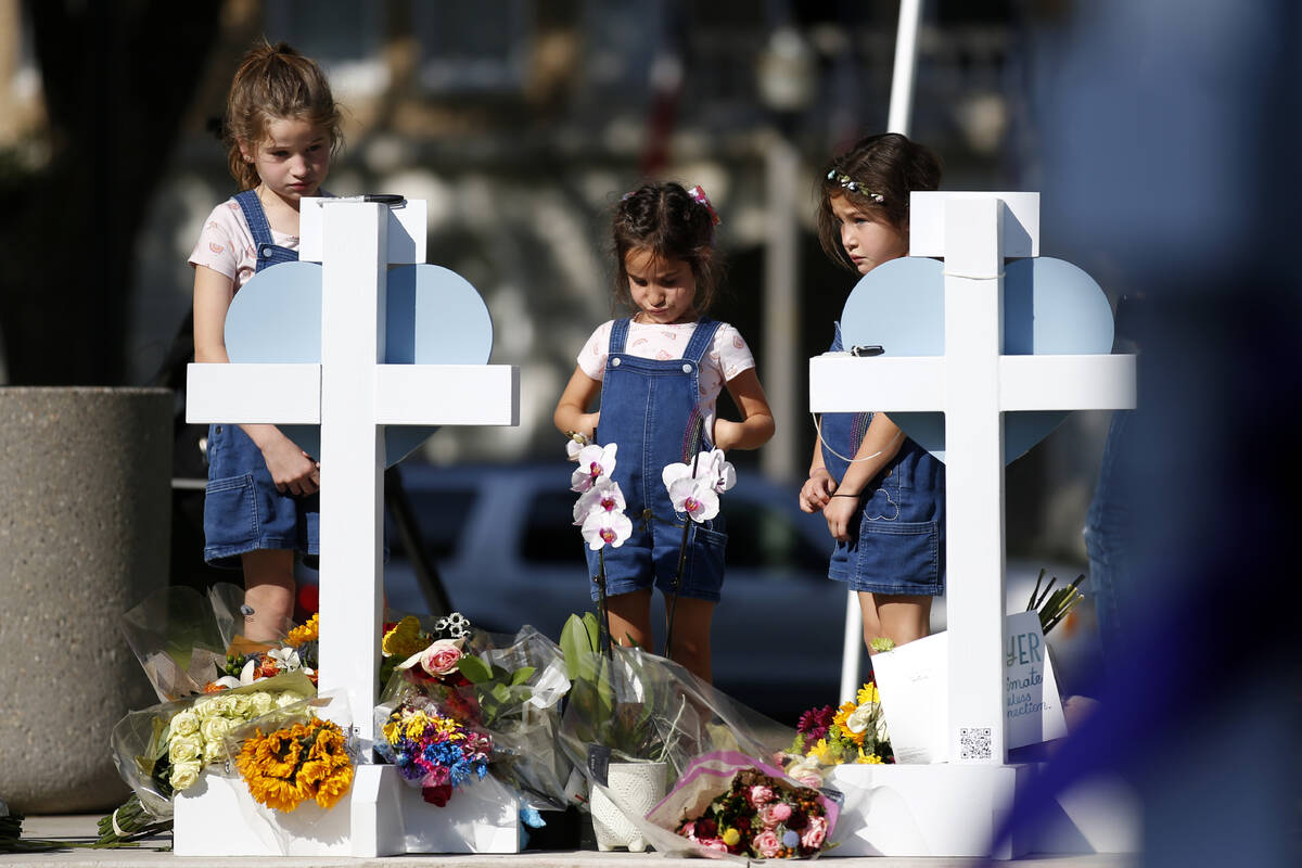 Children pay their respects at a memorial site for the victims killed in this week's elementary ...