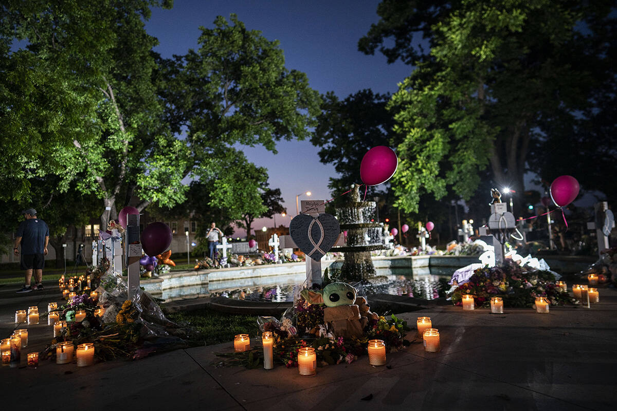Candles are lit at dawn at a memorial site in the town square for the victims killed in this we ...