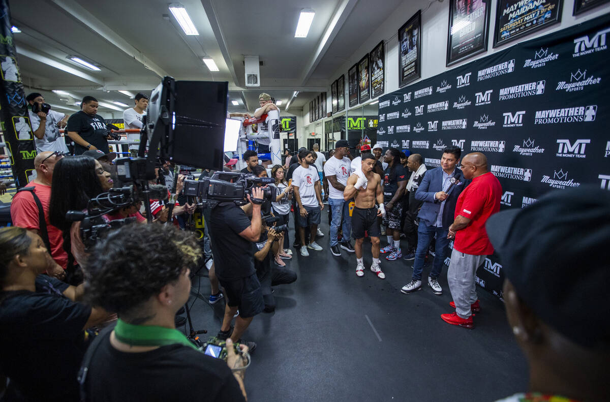 Boxer Rolando Romero, center, looks on as he awaits an interview during media day workouts at t ...