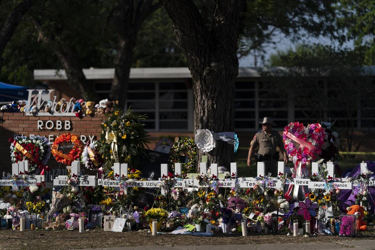 Flowers and candles are placed around crosses at a memorial outside Robb Elementary School to h ...