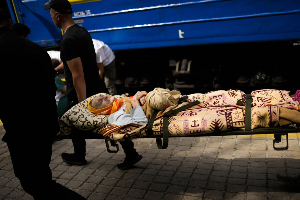 An elderly patient is carried on a stretcher to board a medical evacuation train run by MSF (Do ...