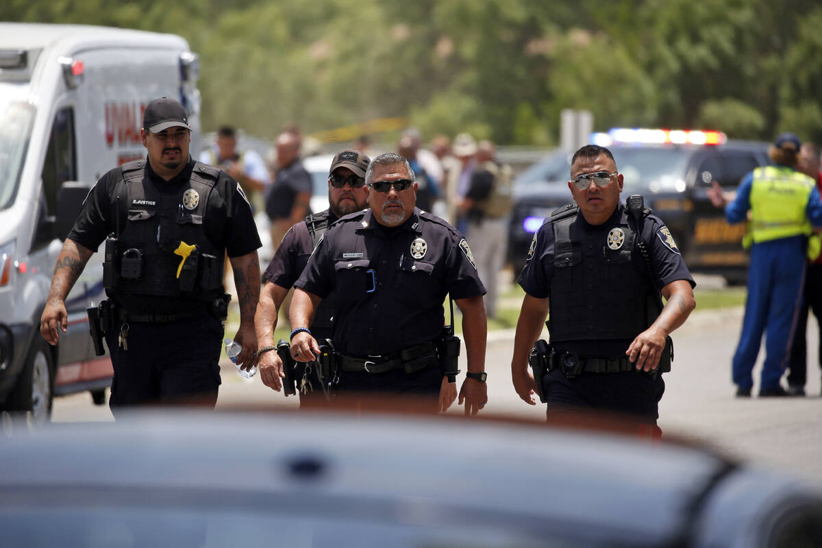 Police walk near Robb Elementary School following a shooting, Tuesday, May 24, 2022, in Uvalde, ...