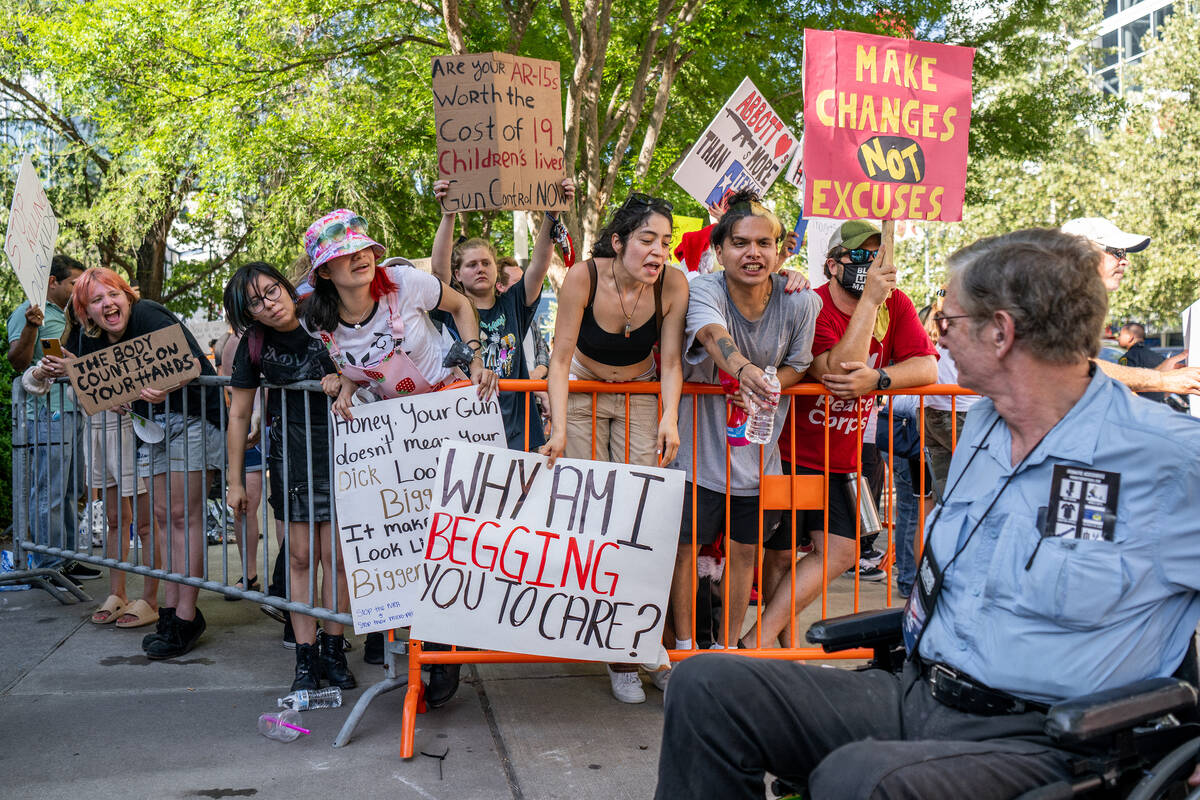 Gun control advocates confront a man passing by from the National Rifle Association annual conv ...