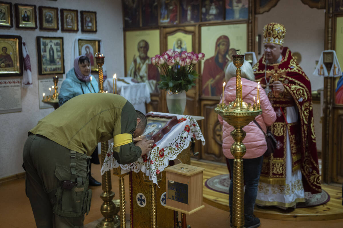 A Ukrainian serviceman attends a Sunday Ukrainian Orthodox mass in Kharkiv, eastern Ukraine, Su ...