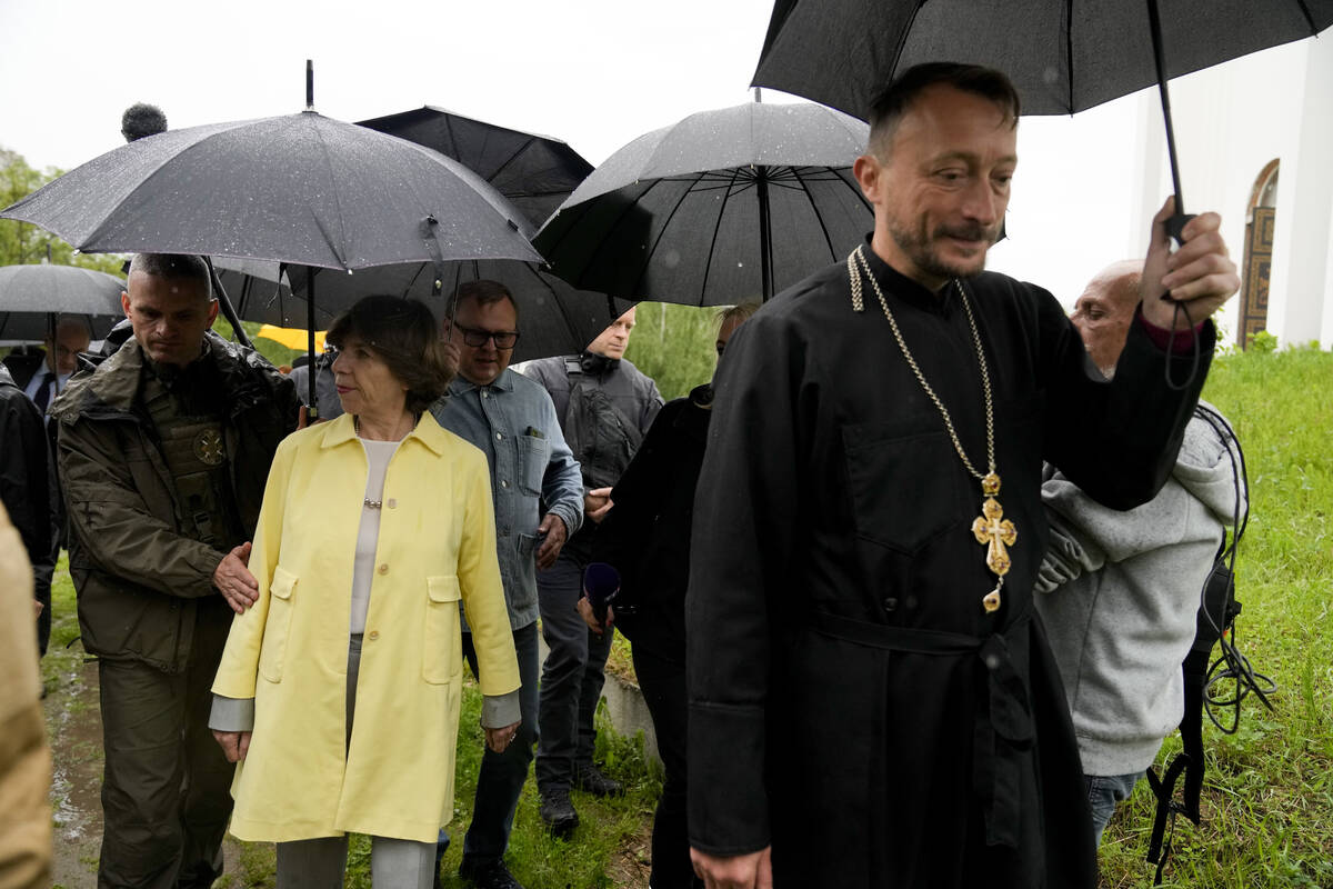 French Foreign Minister Catherine Colonna, left, visits Bucha's church on the outskirts of Kyiv ...