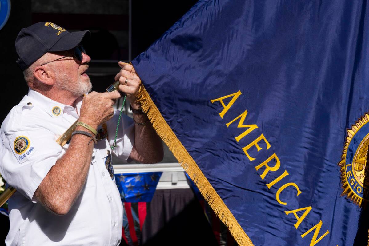 Marine Corps veteran Walter Cheatham unfurls the American Legion flag at Lake Sahara South Park ...