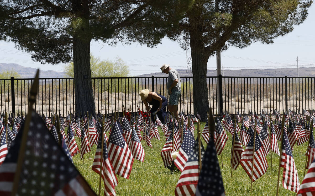 Kim Wilson of Henderson places flowers at the graves of her parents and brother as her husband ...