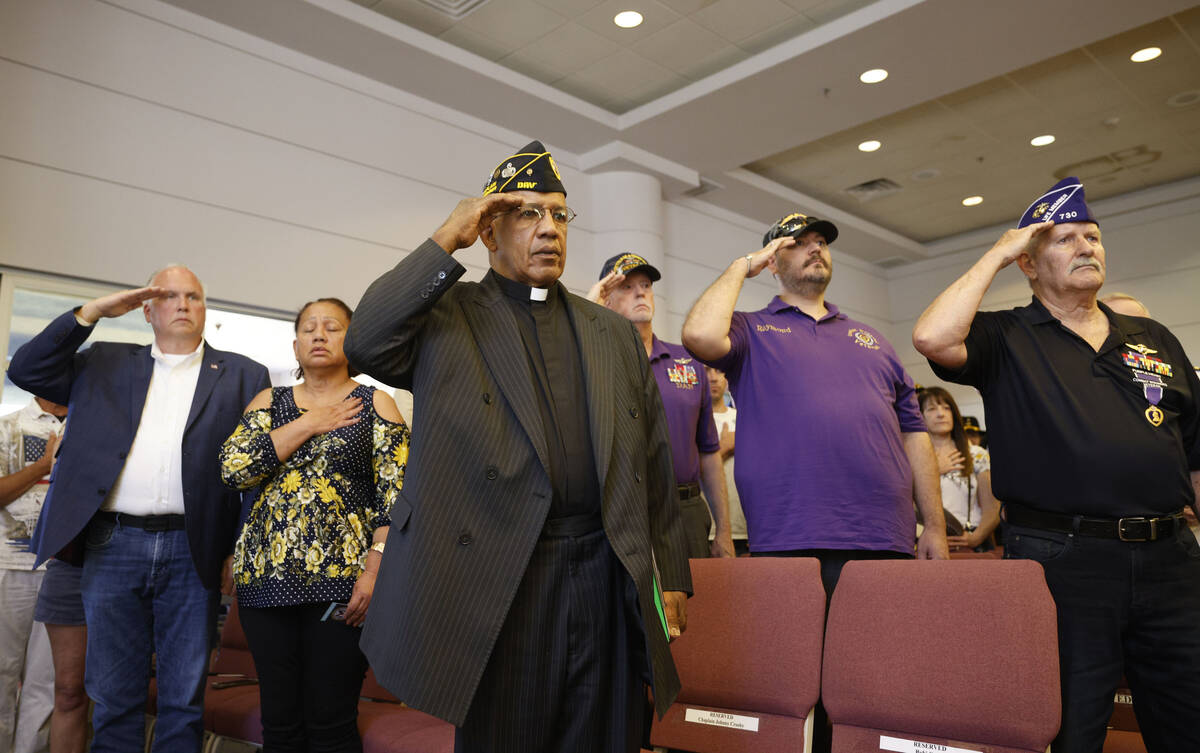 Chaplain Johnny Crosby of Disabled American Veterans Chapter 13, center, salutes during a Memor ...