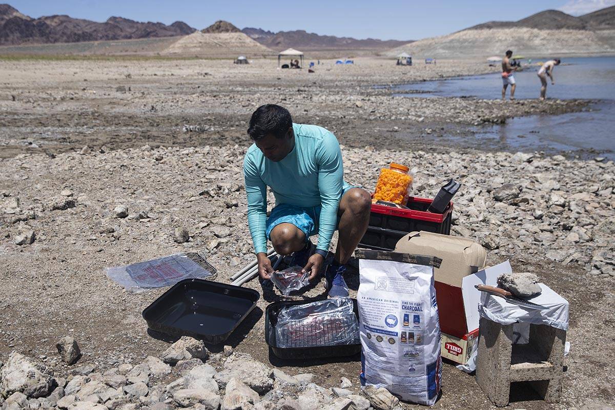Erick Ferrara of Las Vegas gets his grill ready during a visit to Lake Mead with his children, ...