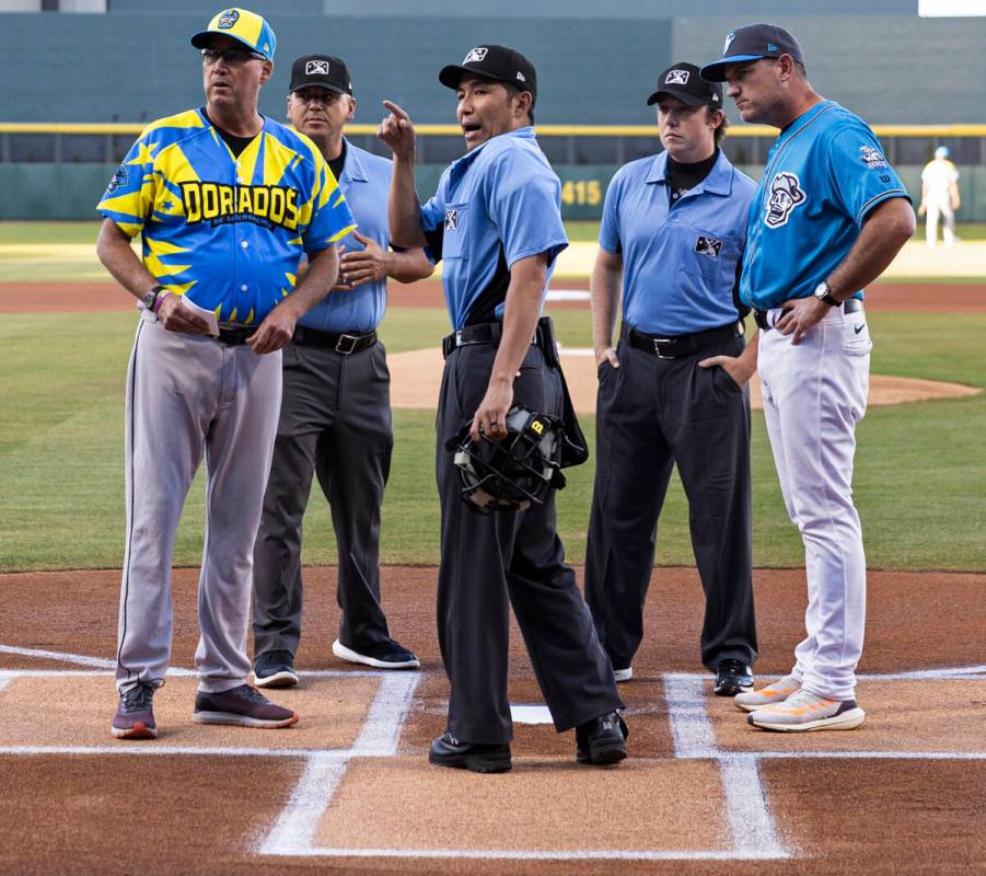 Home plate umpire Takahito Matsuda, middle, meets with both teams and fellow umpires before the ...