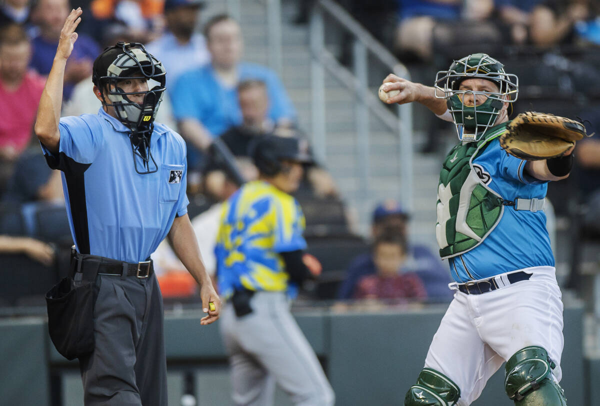 Home plate umpire Takahito Matsuda, left, confirms a strike out using the Automated Ball-Strike ...