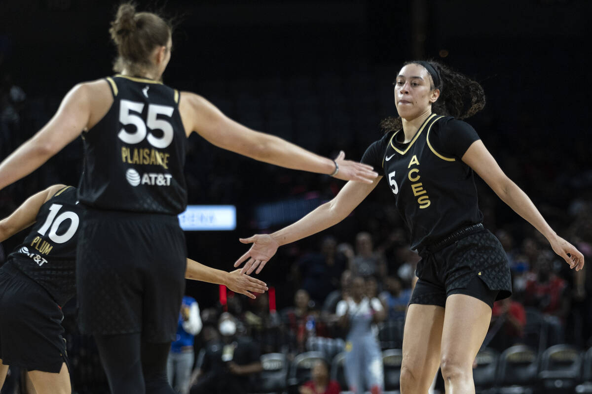 Las Vegas Aces forward Dearica Hamby (5) slaps hands with guard Kelsey Plum (10) and forward Th ...