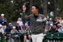 Kevin Na tips his cap after putting out on the 18th hole during the second round at the Masters ...