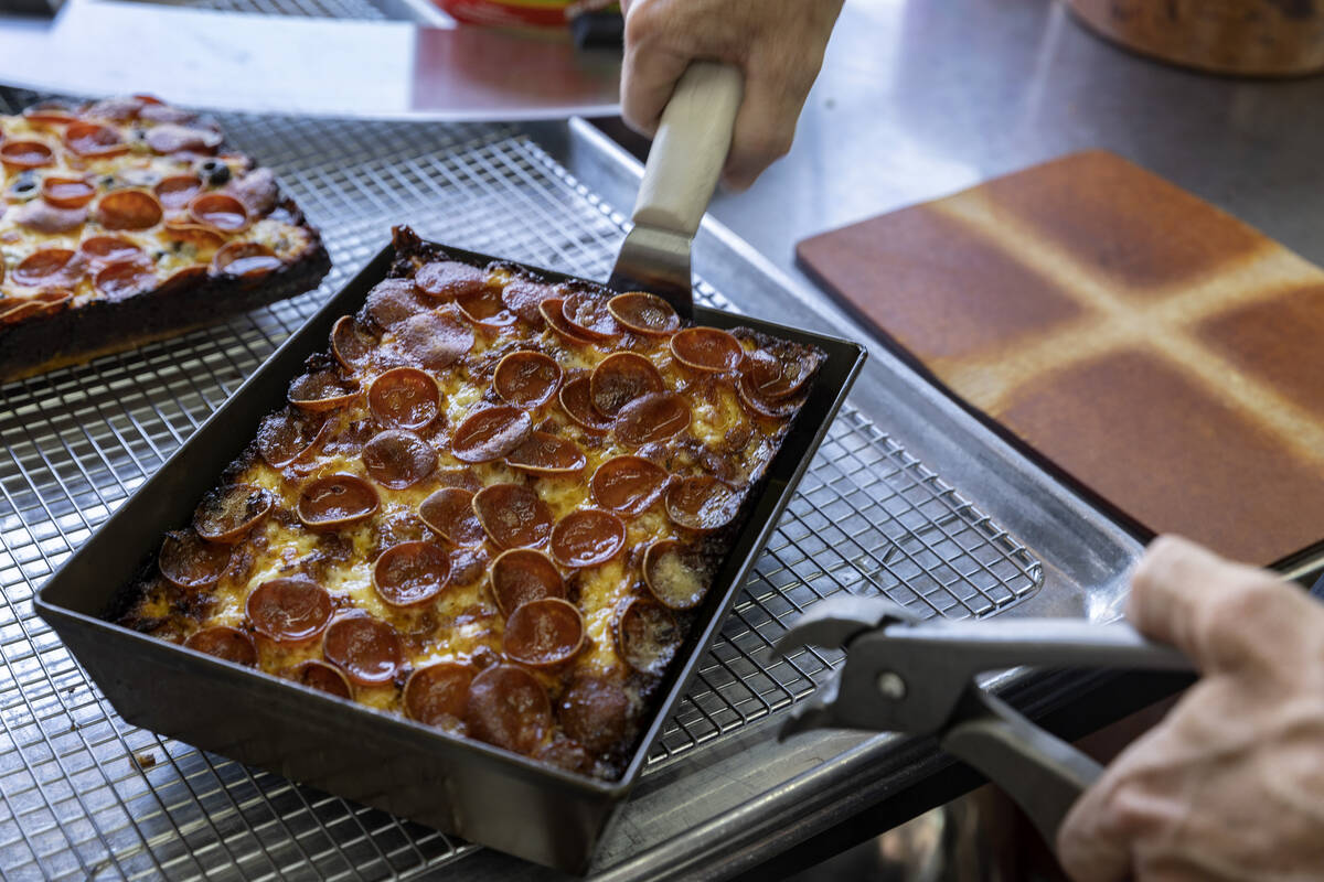 Chef Brett Geiger prepares to slice a Detroit-style pizza at his food truck Izzy’s Pizza ...