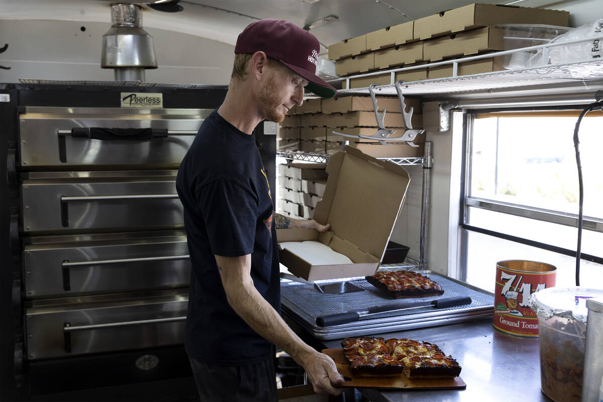 Chef Brett Geiger boxes a Detroit-style pizza at his food truck Izzy’s Pizza Bus outside ...