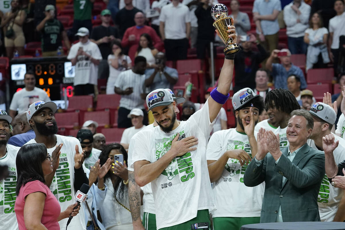 Boston Celtics forward Jayson Tatum raises the NBA Eastern Conference MVP trophy after defeatin ...