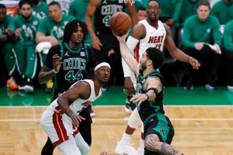 Boston Celtics' Jayson Tatum (0) shoots against Miami Heat's Jimmy Butler (22) during the first ...