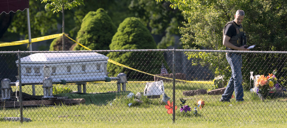 A FBI agent works at the scene of a shooting Thursday, June 2, 2022 at Graceland Cemetery in Ra ...