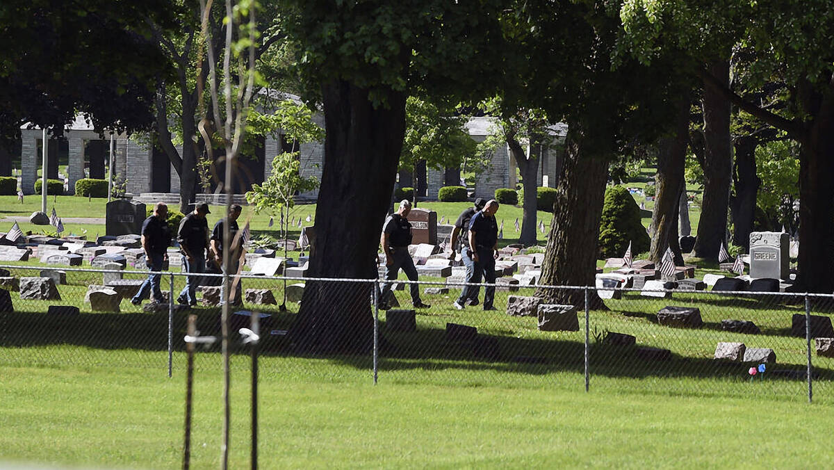 Officers investigate after shots were fired in or near Graceland Cemetery in Racine, Wis., on T ...