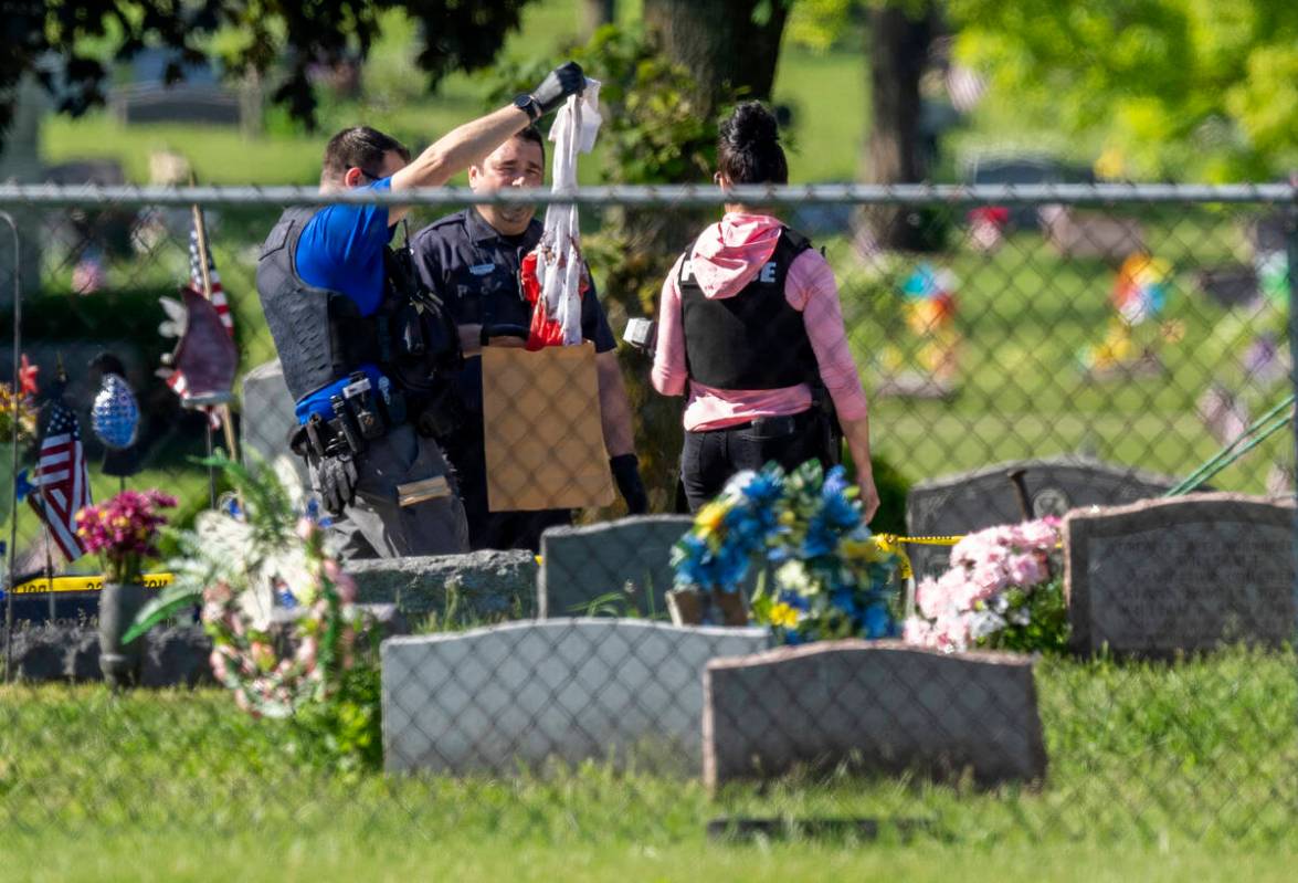 Law enforcement examine a bloody garment while working at the scene of a shooting Thursday, Jun ...