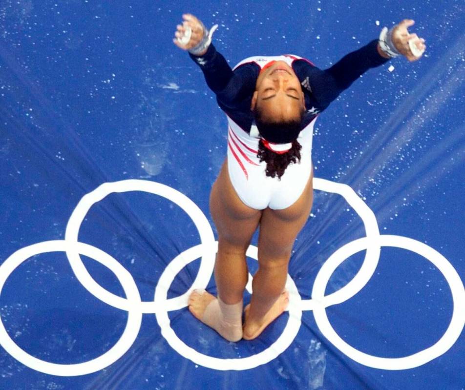 FILE - USA gymnast Tasha Schwikert sticks her landing on the uneven bars during the women's gym ...