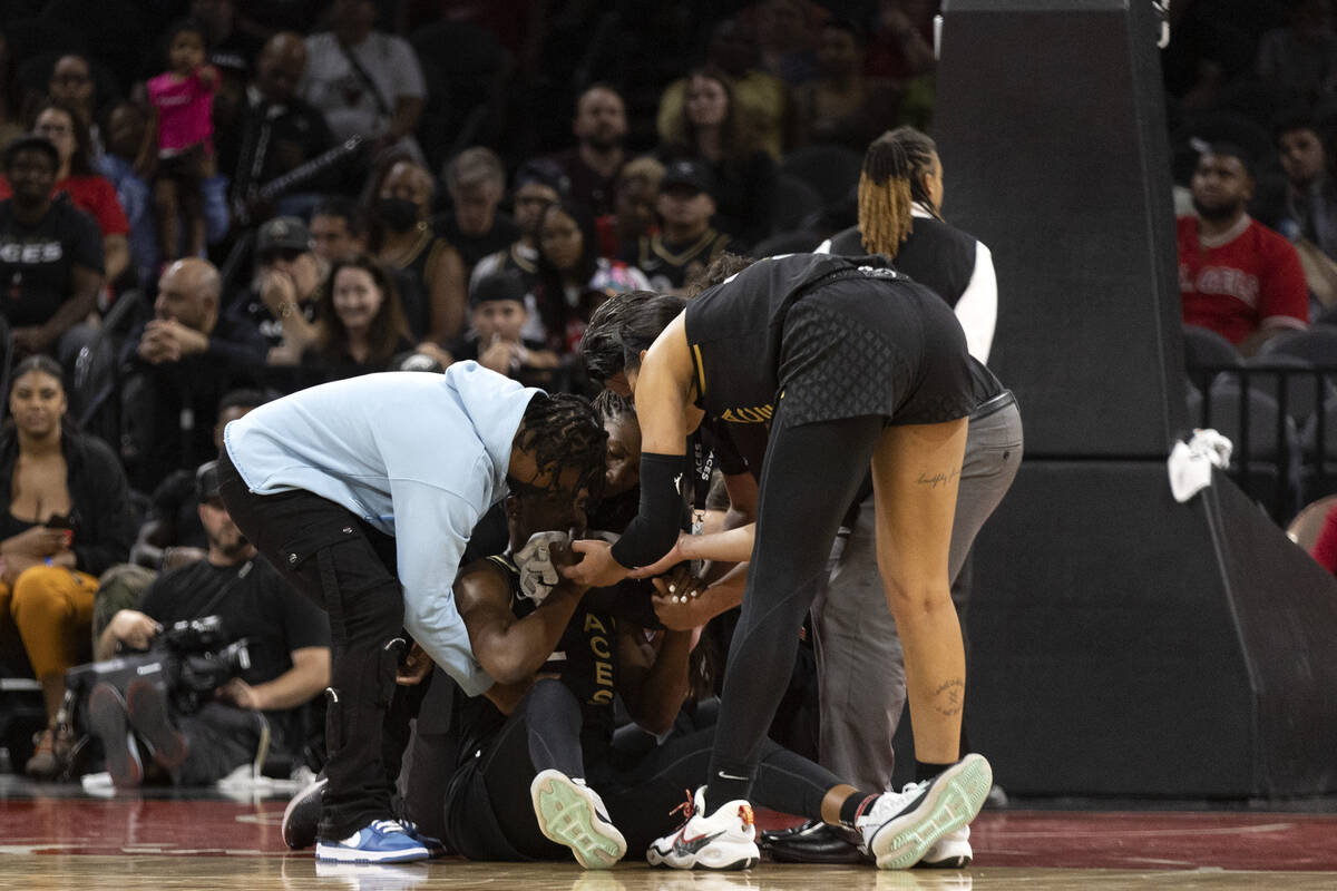 Las Vegas Aces players surround guard Chelsea Gray after she was injured during the second half ...