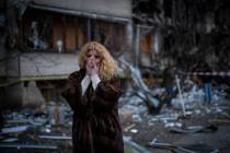 Natali Sevriukova stands near her house after a rocket attack in Kyiv, Ukraine, Friday, Feb. 25 ...
