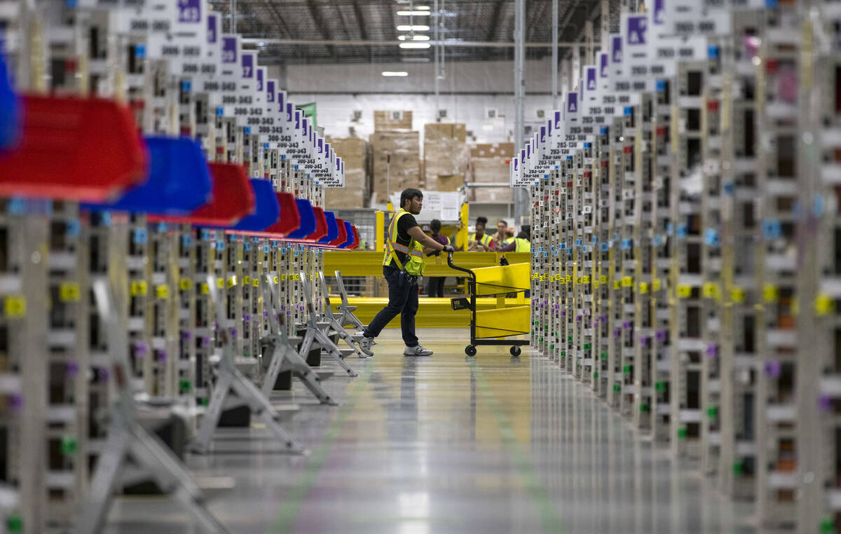 A worker navigates the aisles while preparing customer orders at Amazon's North Las Vegas fulfi ...