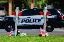A police SUV passes by a memorial in honor of the 21 victims of a mass shooting at Robb Element ...