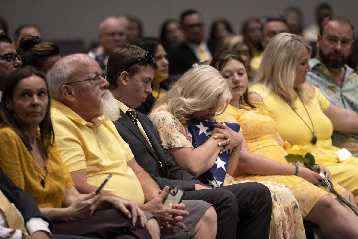 Jenn Closi, center, hugs the flag presented to her during a funeral for her husband Officer Phi ...