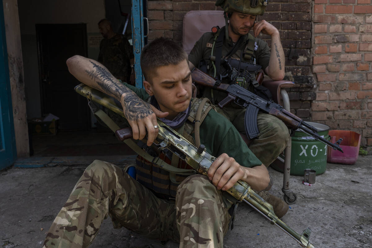 A security member of a medical rescue team cleans his weapon in the Donetsk oblast region, east ...