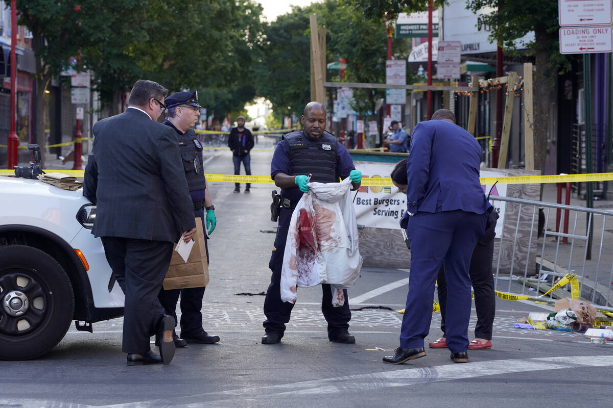 Philadelphia Police investigators work the scene of a fatal overnight shooting on South Street ...