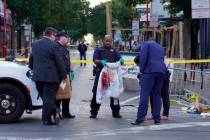 Philadelphia Police investigators work the scene of a fatal overnight shooting on South Street ...