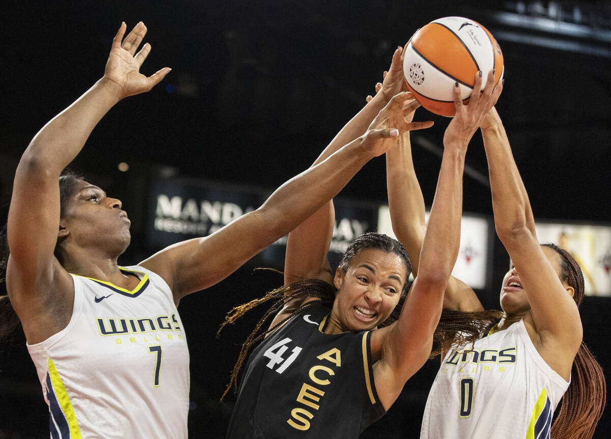 Aces center Kiah Stokes (41) fights for a rebound with Dallas Wings center Teaira McCowan (7) a ...