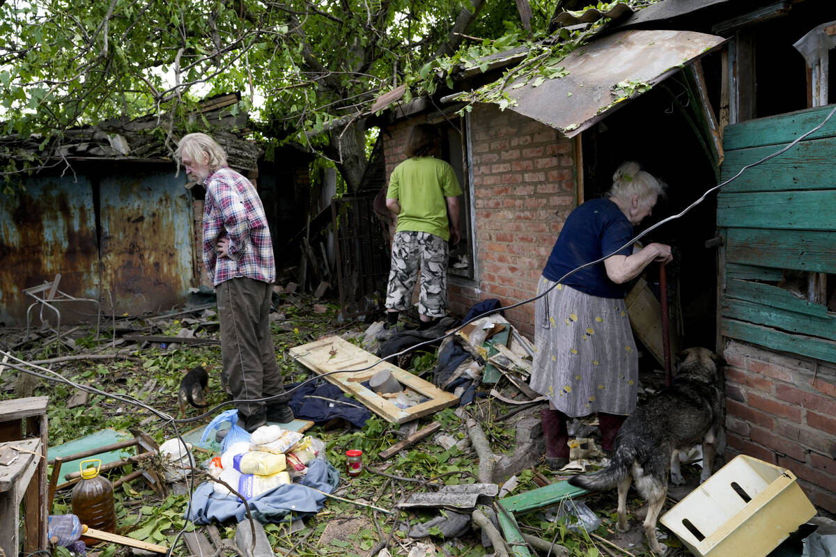 Residents recover belongings from their damaged home after a strike in Druzhkivka, Ukraine, Sun ...